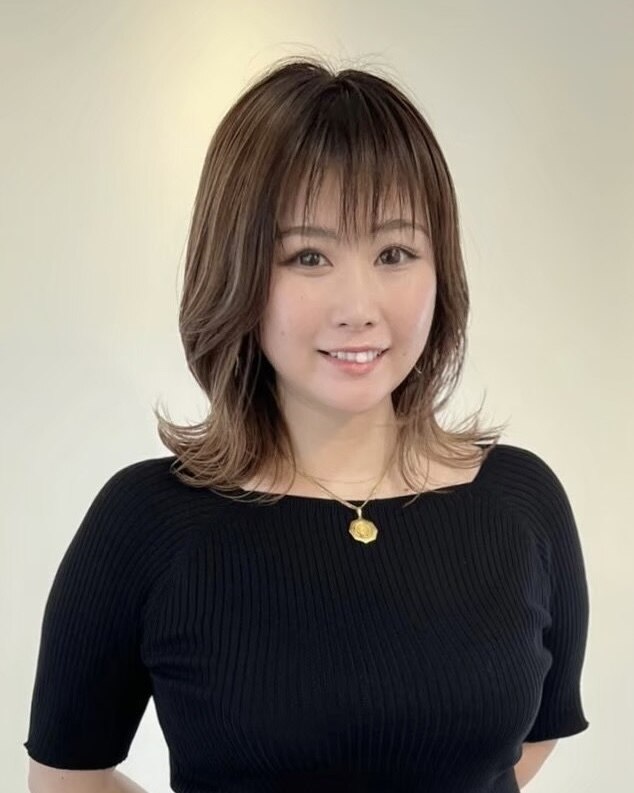 恵美 ネイリスト。ミディアムブラウンヘアに黒ニット